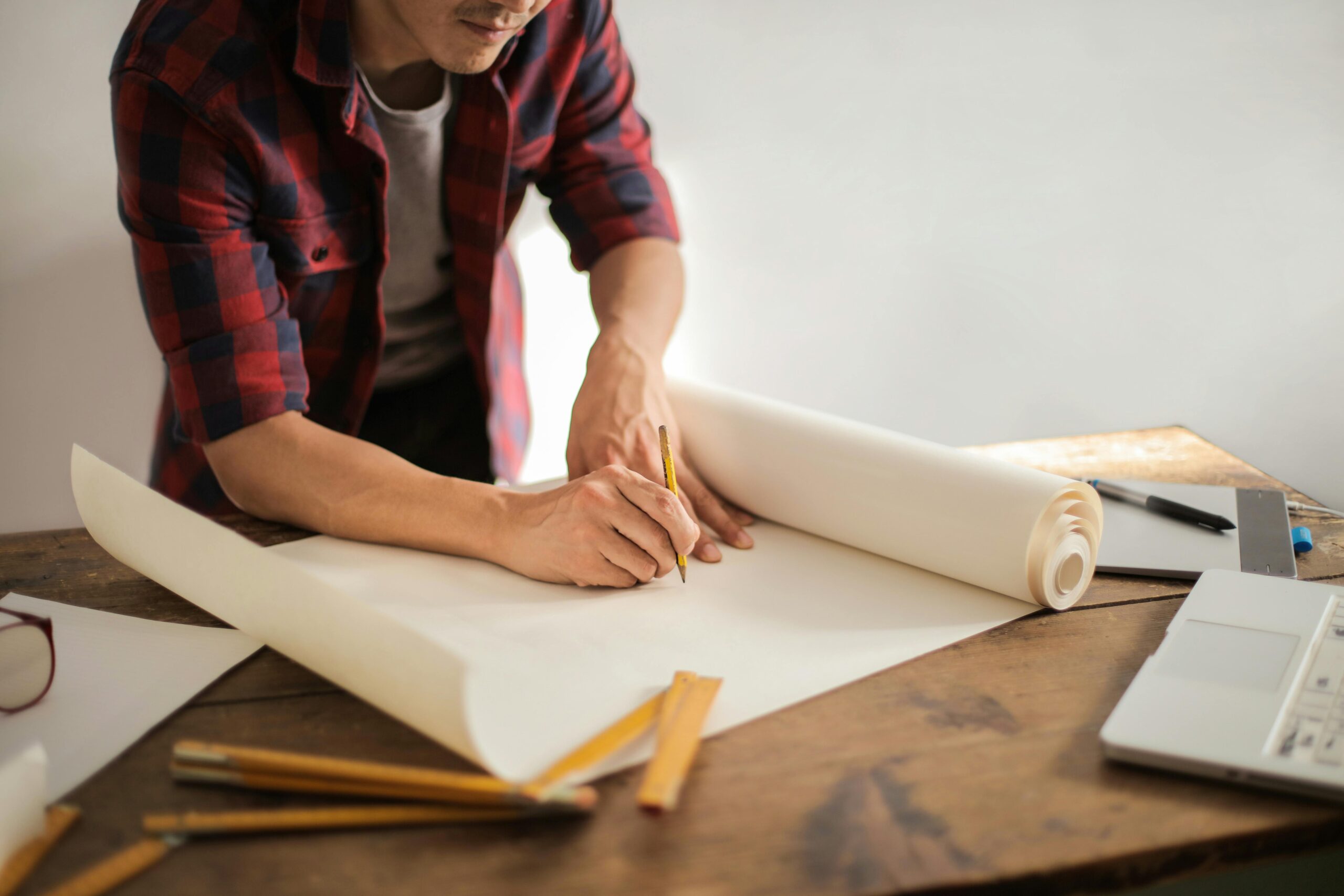 UK construction subcontractor filling out paperwork at a rustic desk, preparing to register for the Construction Industry Scheme (CIS) and manage HMRC compliance.